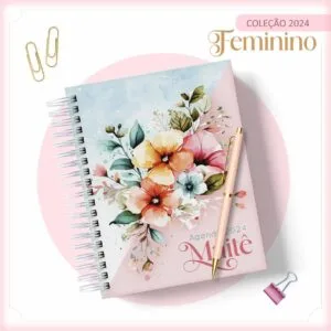 Agenda espiralada com estampa floral colorida, caneta e clipes de papel.
