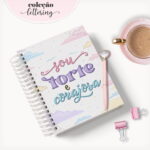 Caderno espiralado com frase motivacional e elementos decorativos