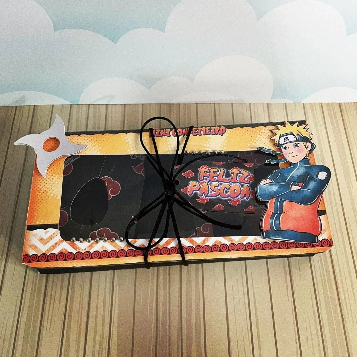 Arquivos De Corte Páscoa Naruto Mini Confeiteiro 4 Arte com caixa decorada, personagem de desenho, shuriken branca e texto Feliz Páscoa