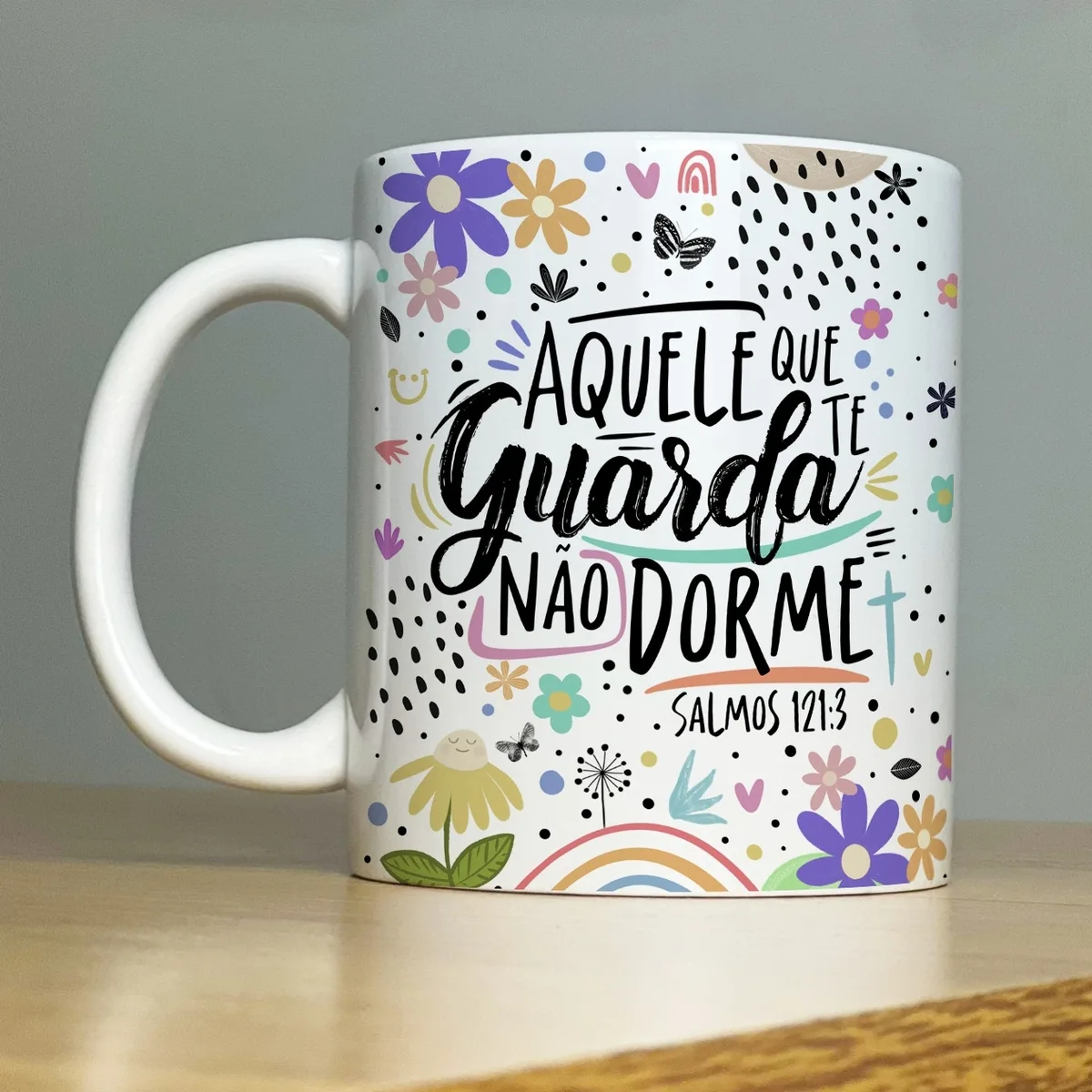 Caneca branca com ilustração colorida e texto "AQUELE QUE TE GUARDA NÃO DORME".