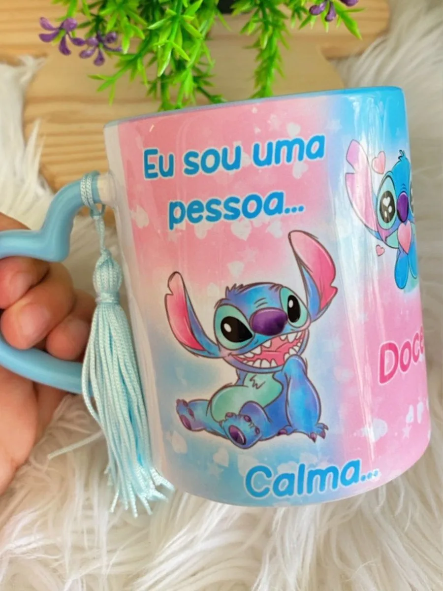 Arte Caneca Stitch Vocês Que Me Estressam 1 Caneca azul com alça de coração e desenho de personagem azul.