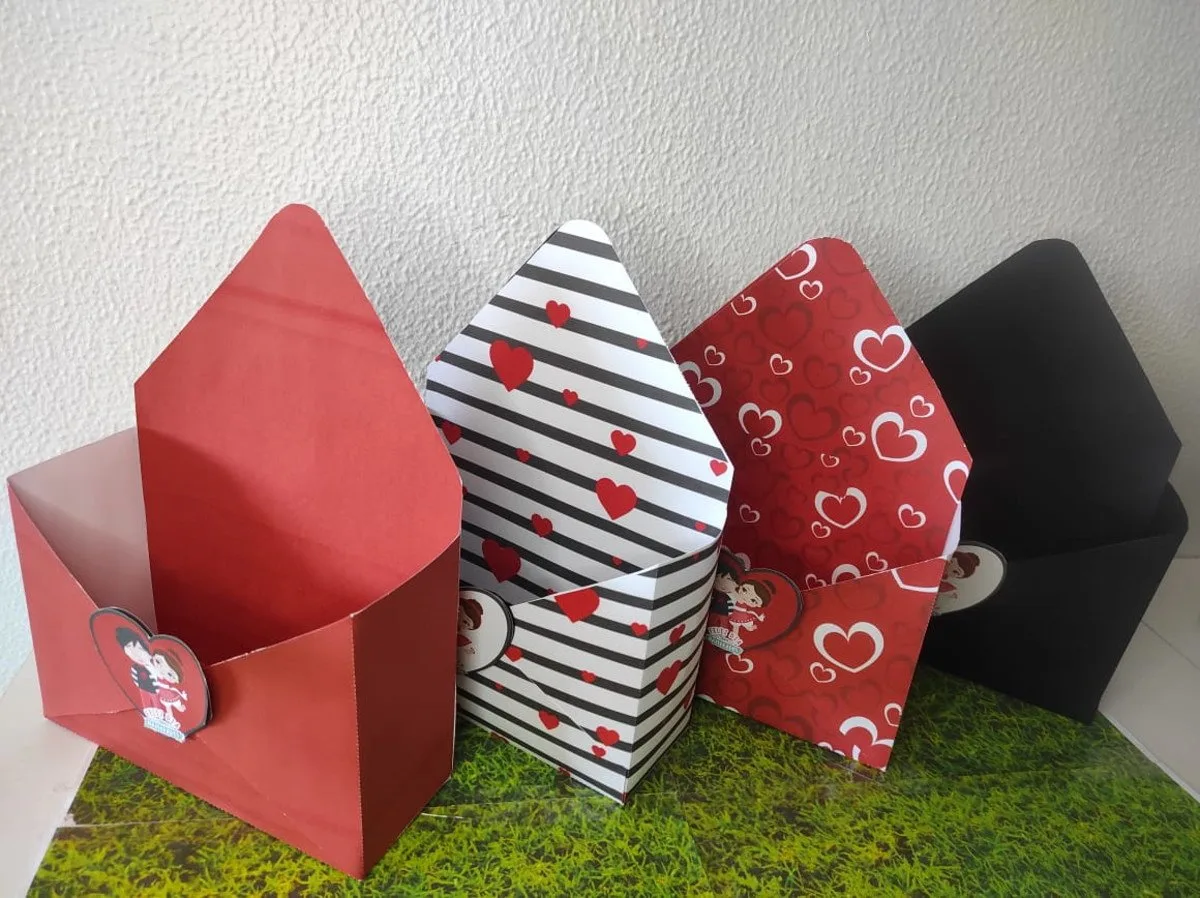Quatro caixas de papel em formato de envelope sobre superfície com estampa de grama