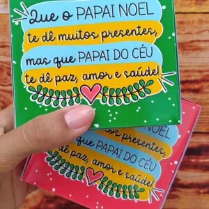 Caixinhas de Doces Natal 8 Mão segurando caixa verde estampada com mensagem em fundo de madeira