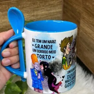 Caneca Sorriso Torto (ele) - Png 7 Caneca branca com alça de colher azul contendo ilustrações de desenhos animados.
