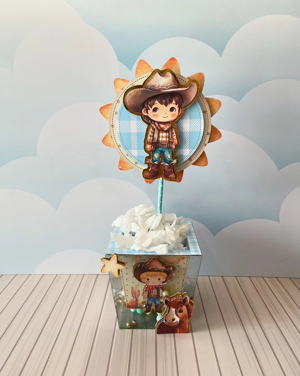 Centro de mesa decorativo com tema de vaqueiro infantil e sol ao fundo.