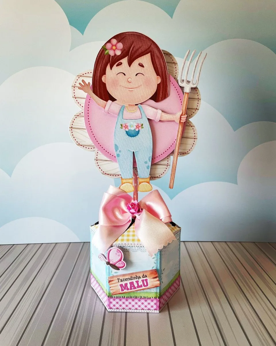 Centro de Mesa Fazendinha Menina 1 Topo de bolo de fazendeira com menina segurando um forcado de jardim.