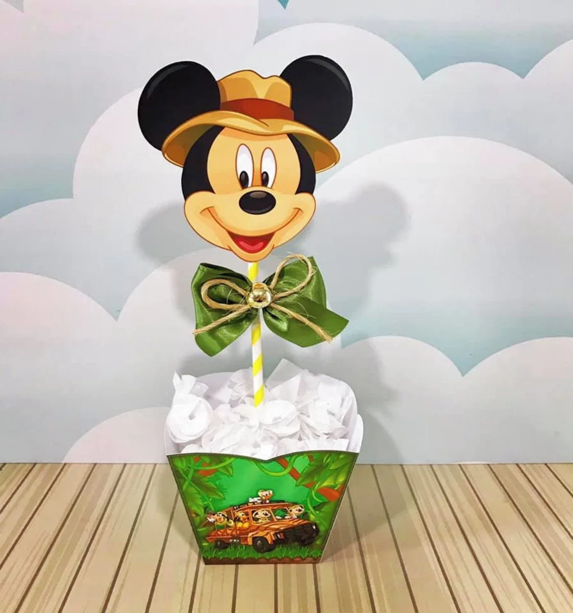 Topo de bolo com o rosto de um personagem animado usando chapéu em um vaso decorado