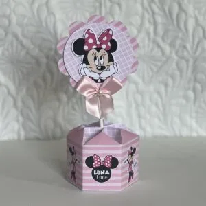Decoração de festa rosa com personagem de desenho feminino e laço.