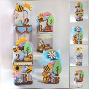 Artesanato em papel com tema de abelhas e colmeias decorando embalagens cilíndricas.