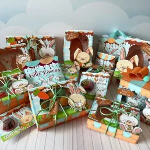 Caixas ilustradas com coelhos e cenouras sobre superfície clara diante de nuvens