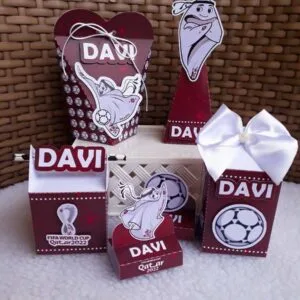 Conjunto de caixas de papel decoradas com tema de futebol e cores escuras.