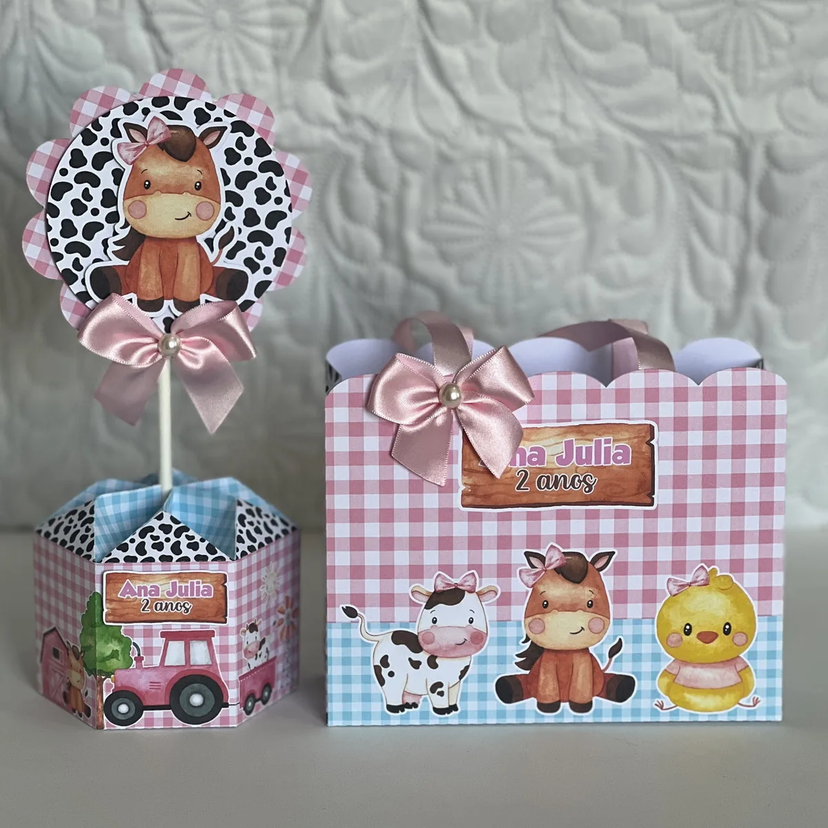 Centros de mesa e sacola decorados com tema fazenda, estampas xadrez e animais.