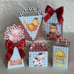 Caixas decoradas de papel com animais de fazenda e laços vermelhos.