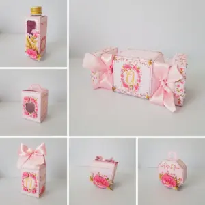 Conjunto de caixas de papel artesanais cor-de-rosa com decoração floral e fitas.