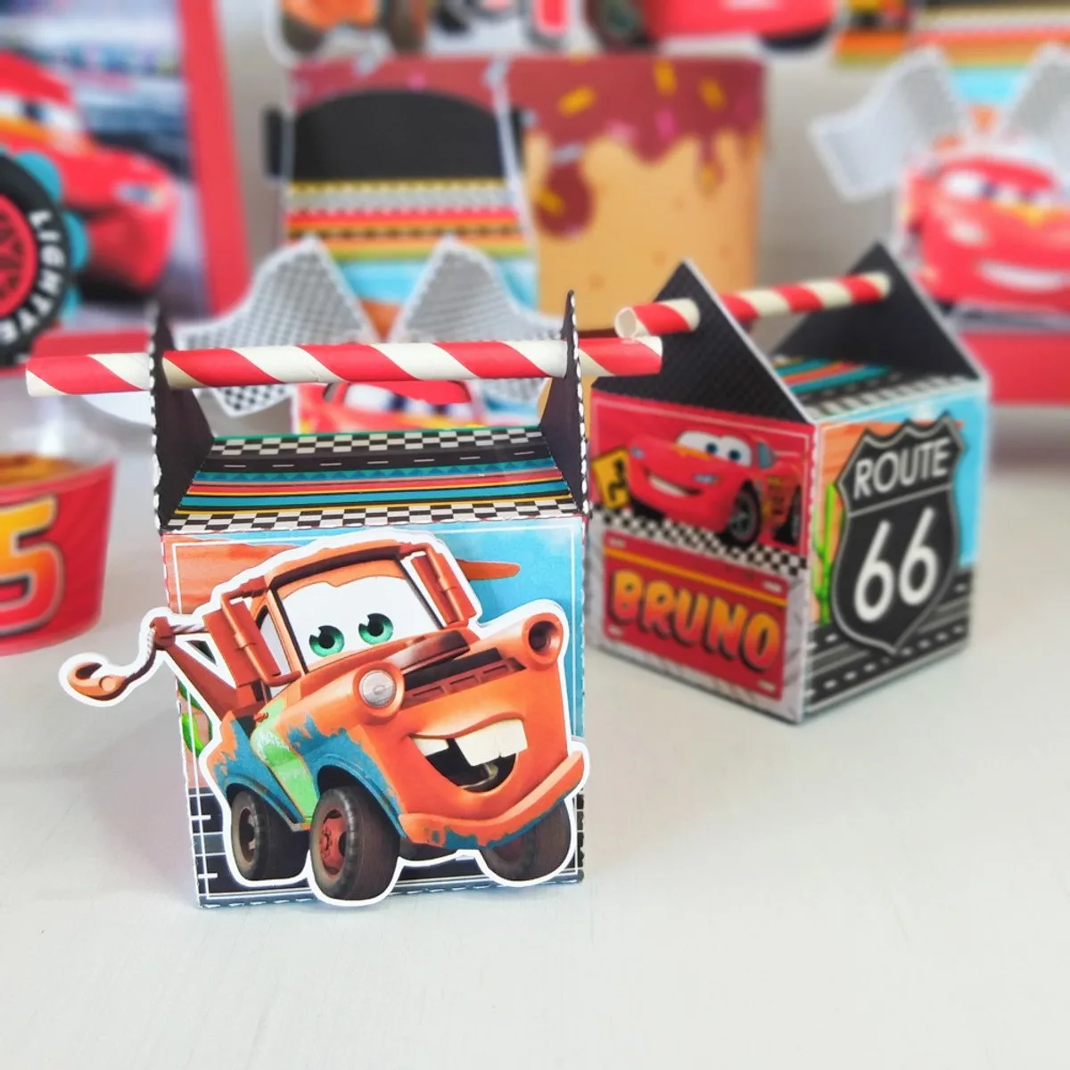 Caixinhas de papel temáticas com desenhos de carros em superfície branca lisa.