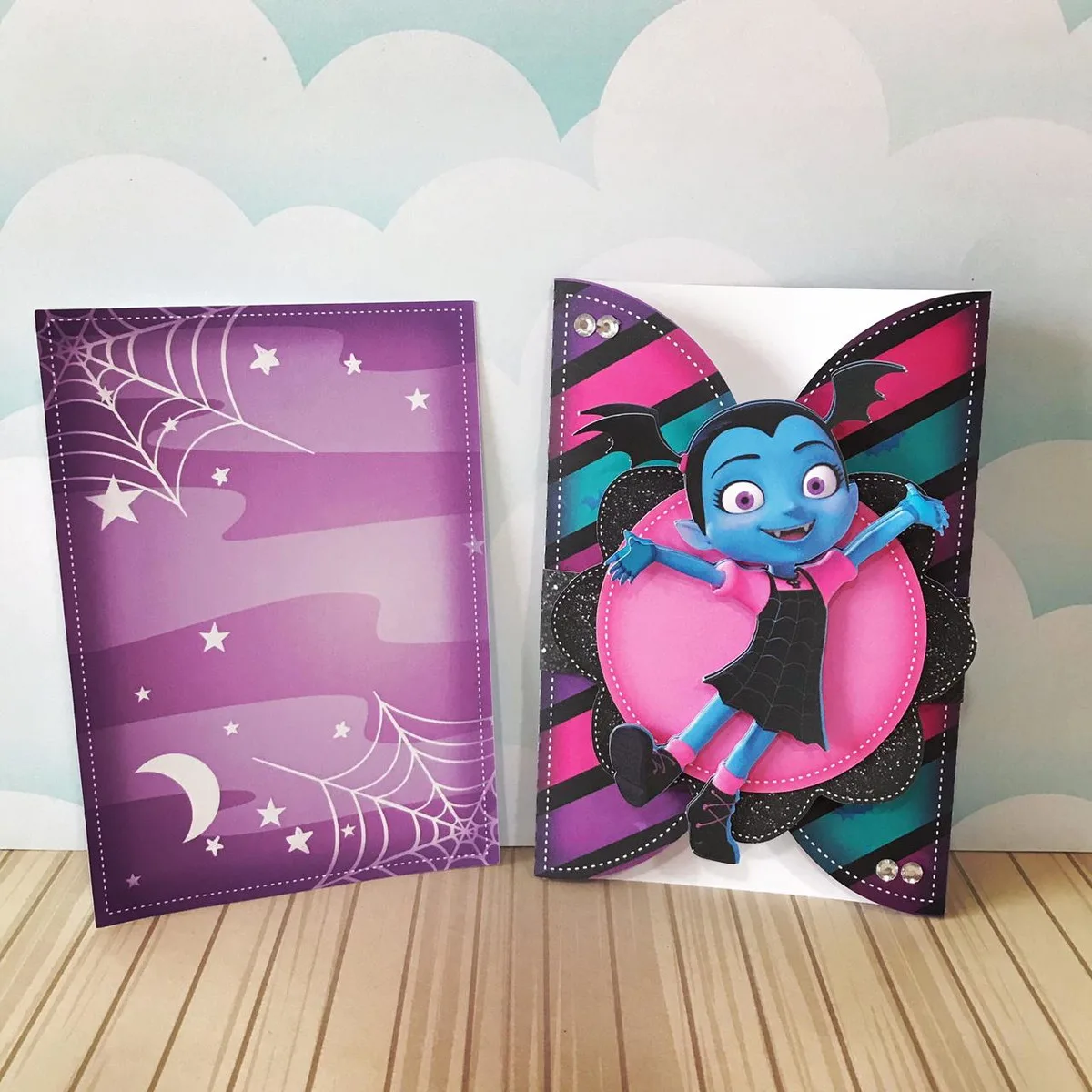 Dois cartões personalizados com tema de vampira em fundo de nuvens claras.