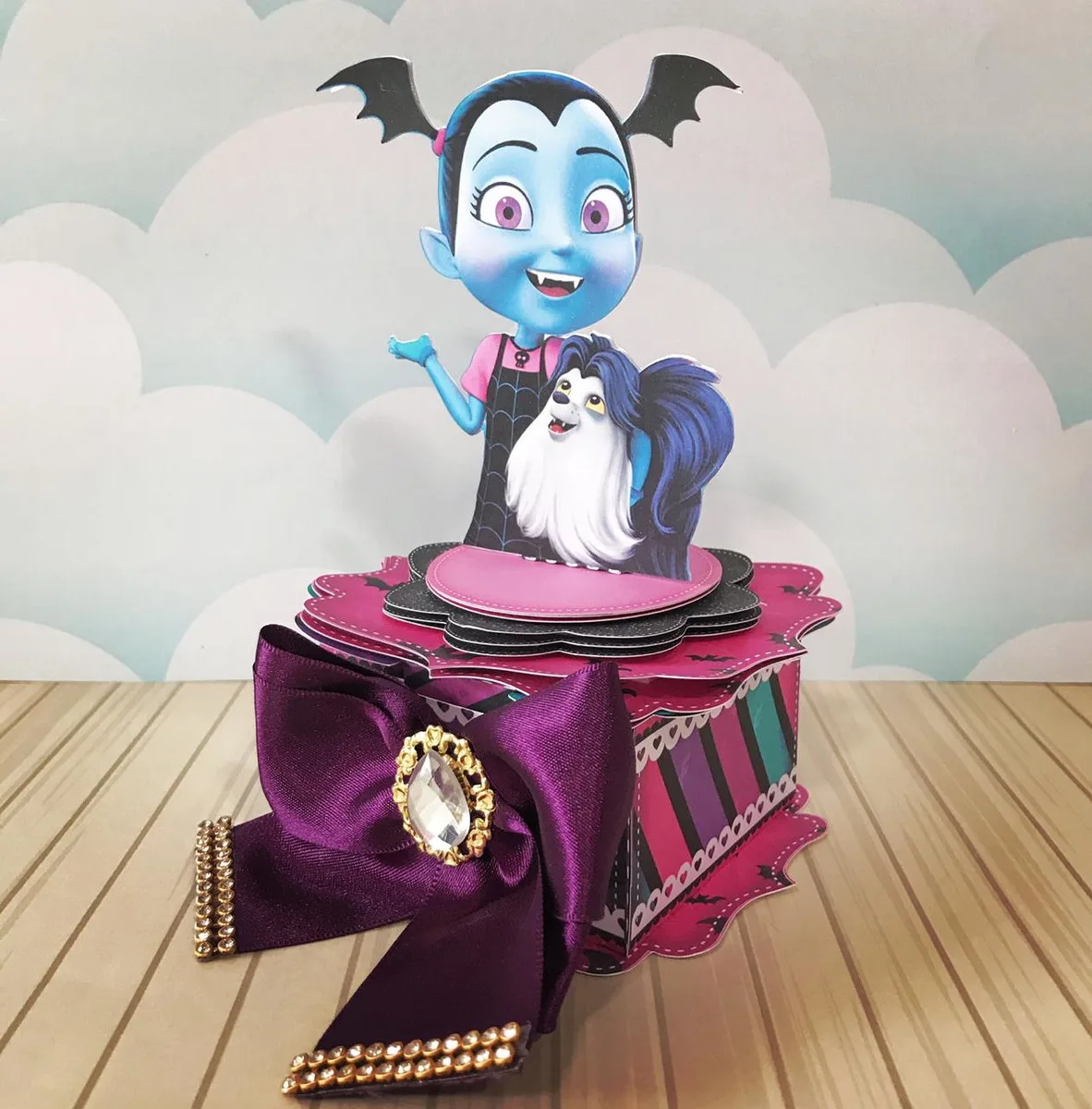 Caixa decorativa de papel com personagem infantil e um cachorro sobre fundo de nuvens.