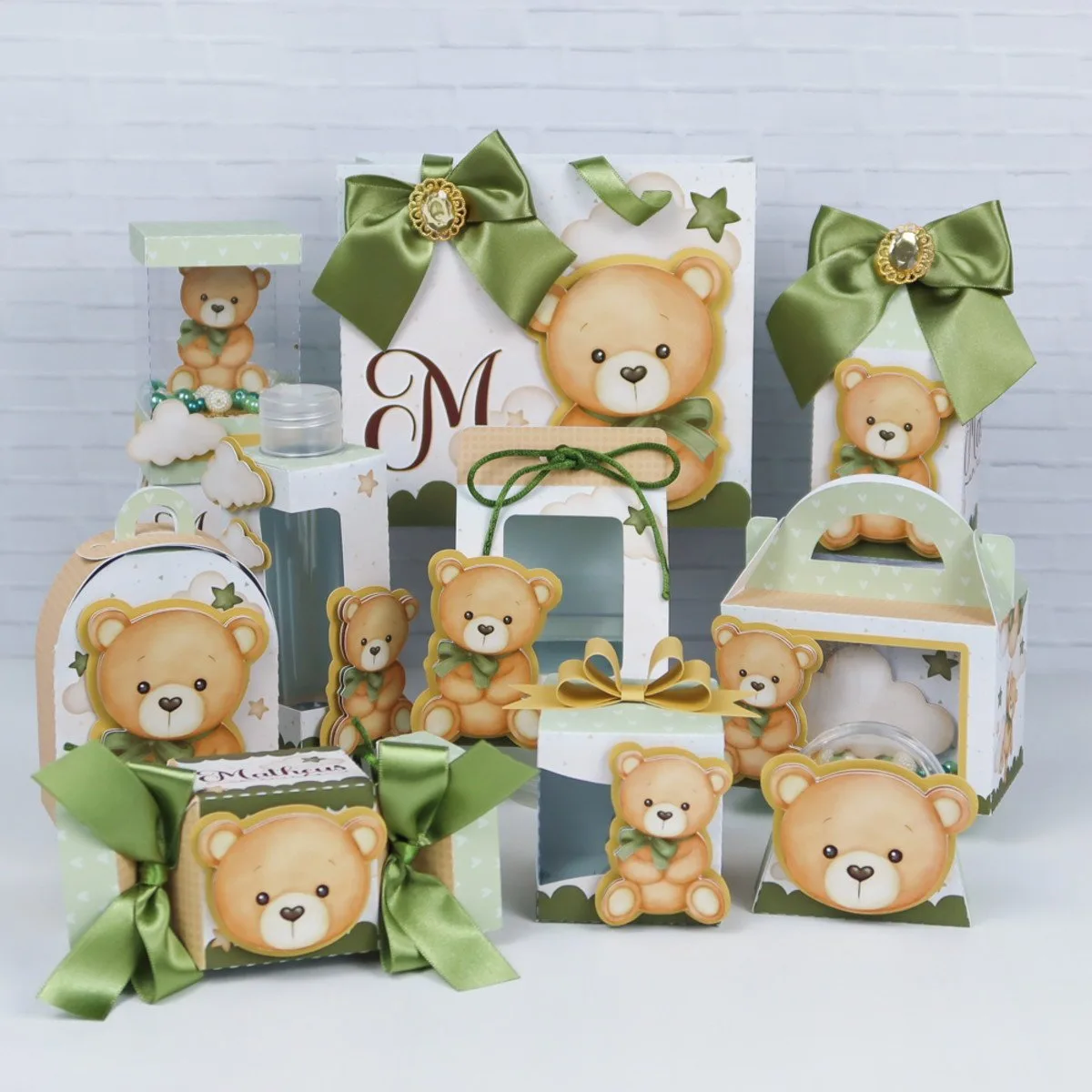 Conjunto de caixas e embalagens decoradas com ursinhos de pelúcia fofos e laços verdes.