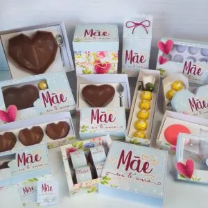 Várias caixas de presente decoradas com corações e chocolates exibidas sobre uma mesa clara.