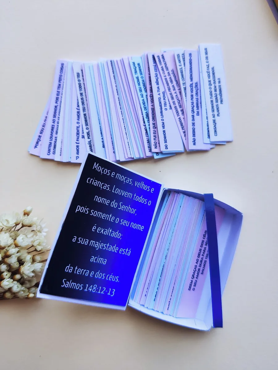Pequenos papéis coloridos com textos impressos espalhados sobre uma superfície clara.