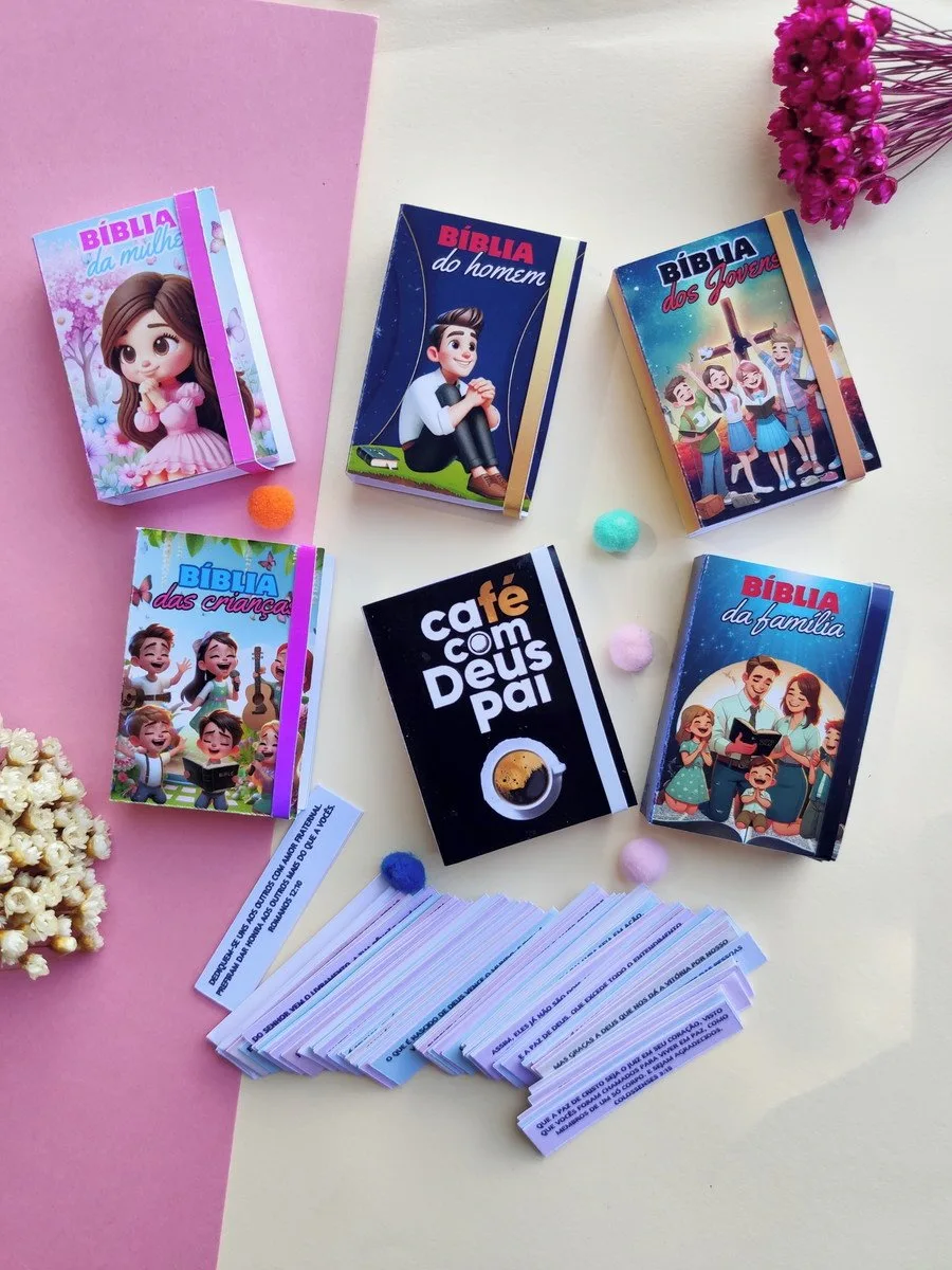 Seis pequenos livros coloridos e pequenos papéis escritos estão dispostos sobre uma superfície rosa.