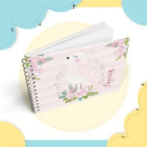 Caderno espiral decorado com ilustração de passarinho e flores em tons rosa.