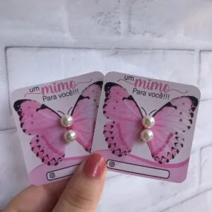 Dois cartões impressos com borboletas cor-de-rosa e pérolas aplicadas.