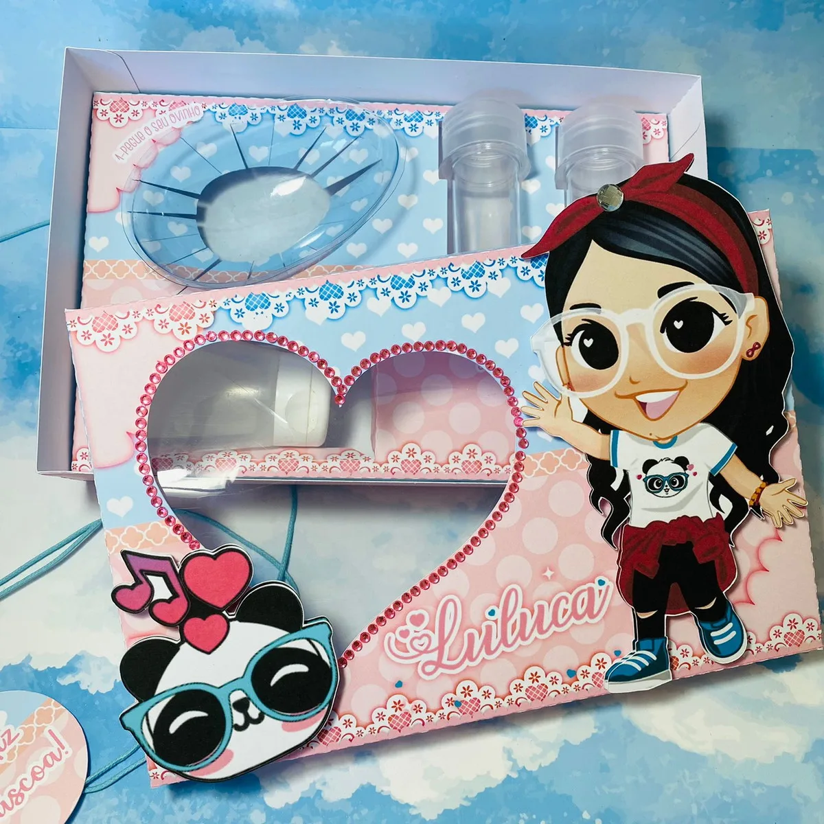 Mini Confeiteiro Luluca 2 Caixa personalizada decorada com personagem de desenho animado e pequenos frascos plásticos.