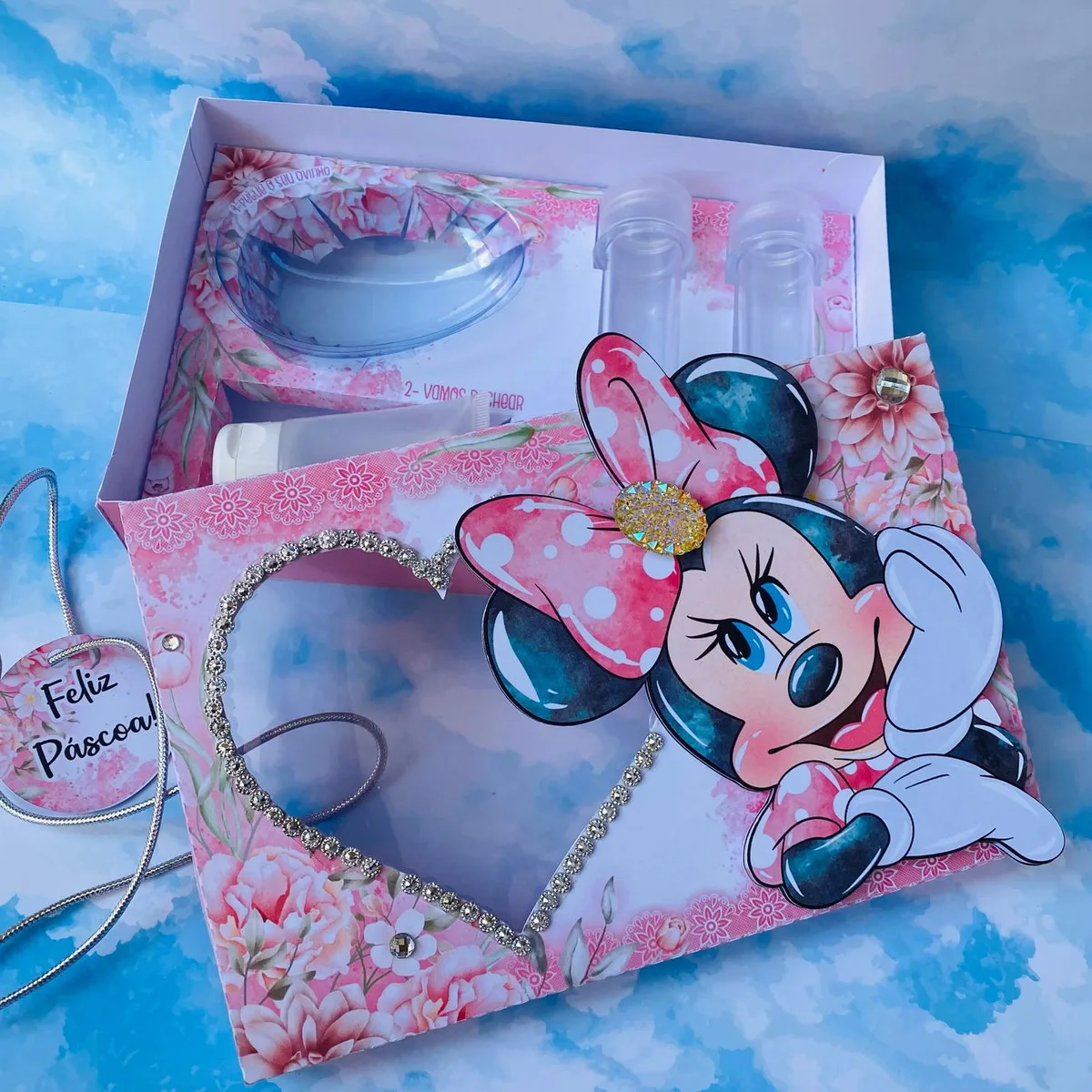 Caixa decorada com tema de personagem infantil, laço rosa, flores e coração brilhante.