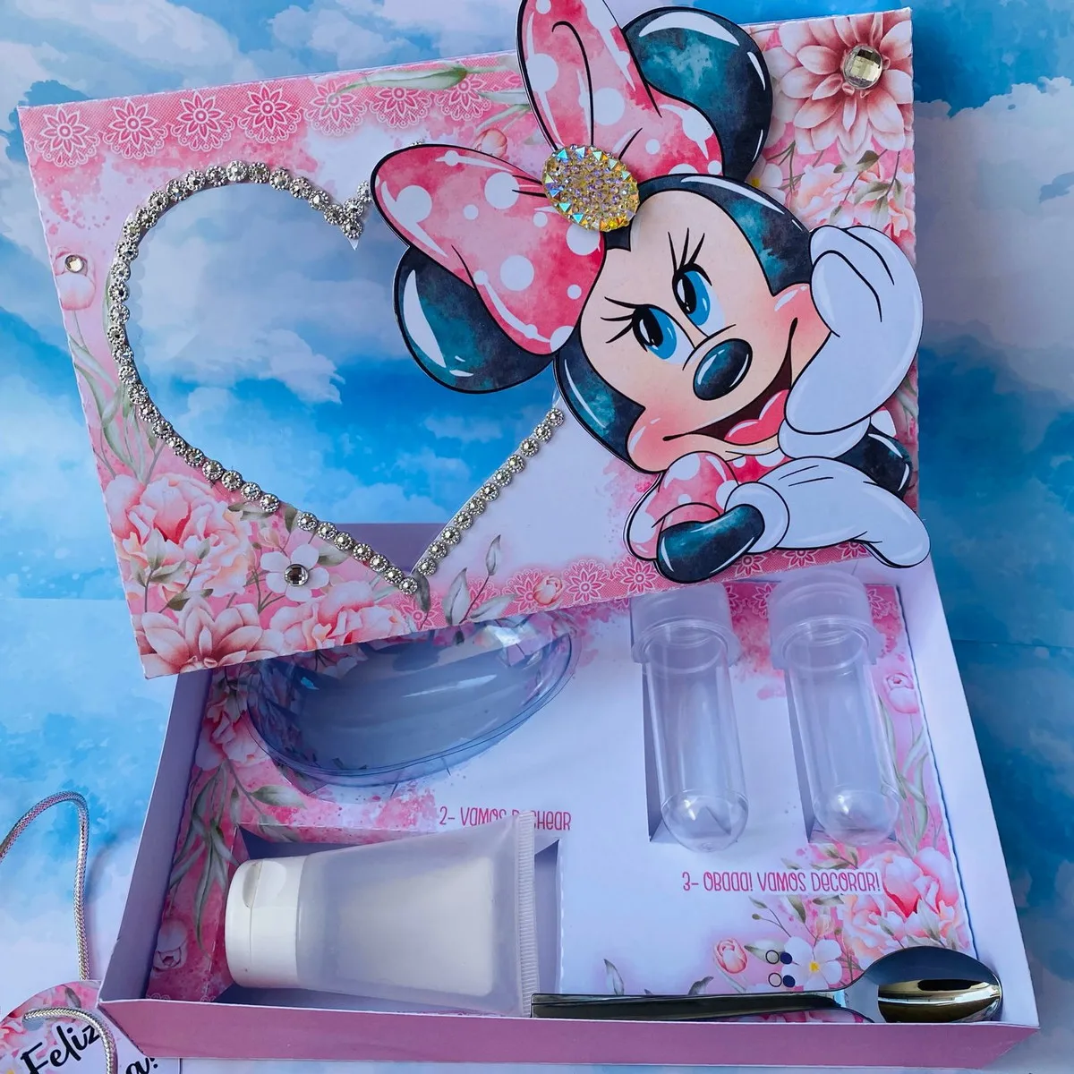 Caixa decorada com personagem de desenho animado e frascos transparentes vazios dentro.