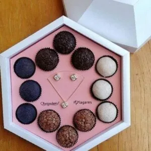 Molde Caixa Brinco e Bombom Dia das Mães Studio e pdf 12 Caixa hexagonal branca com doces variados e um conjunto de joias no centro.