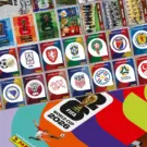 Figurinhas digitais Copa do Mundo 2026 com escudos de seleções e mascotes em PDF.