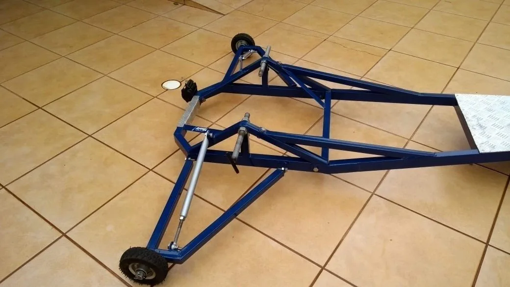 Estrutura tubular azul com rodas sobre piso de cerâmica bege