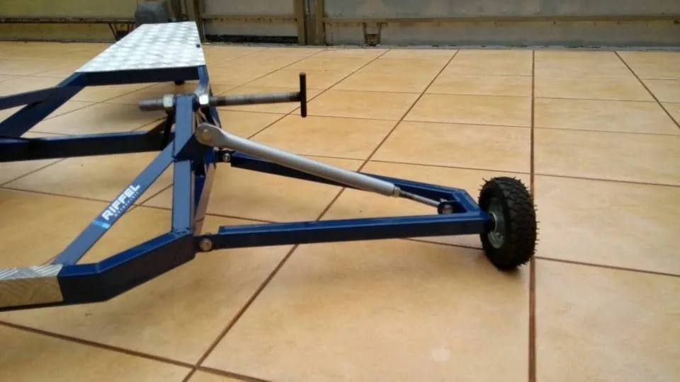 Estrutura metálica azul com plataforma xadrez, haste e roda sobre piso
